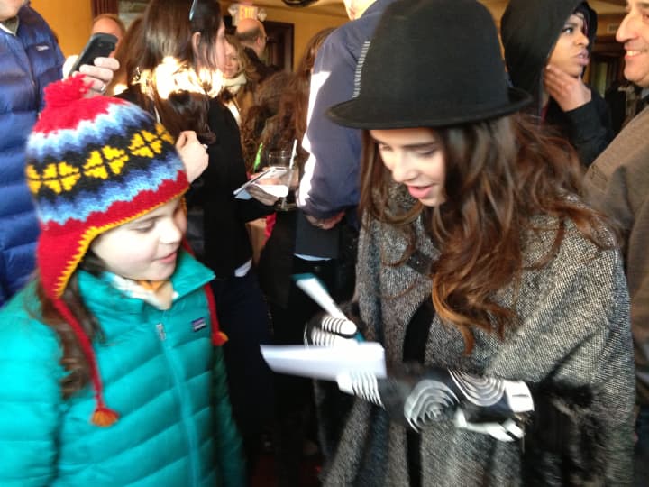 Carly Rose Sonenclar signs an autograph for a young fan at her parade after-party Sunday.