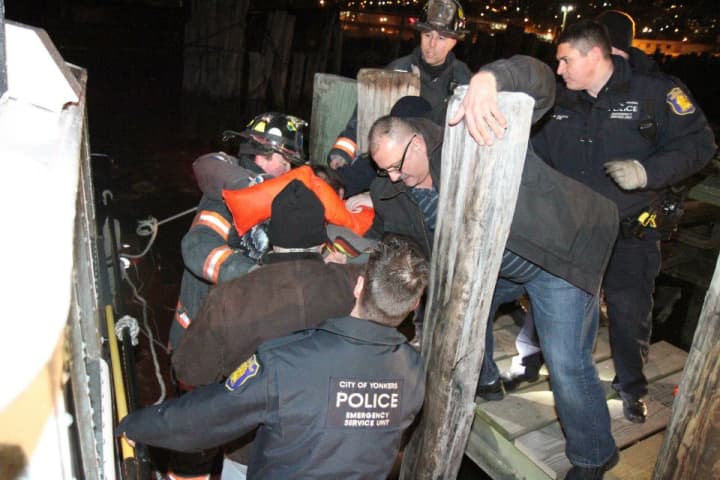 Emergency responders help a pilot and his passenger onto dock after their plane crashed into the Hudson River in Yonkers. 