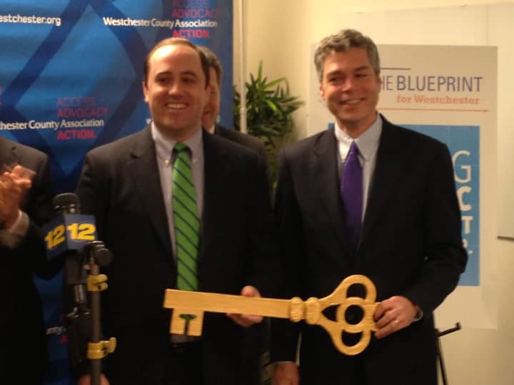 White Plains Mayor Thomas Roach (right) hands Christian Wielage, CEO of PlanGuru, a key to mark the opening of the company&#x27;s new office space at 150 Grand St.