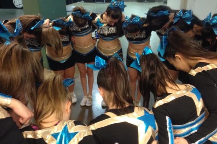 Haywire, a cheerleading team from Stamford-based Gold Coast All-Stars, huddles before taking the floor in a competition in New Jersey.