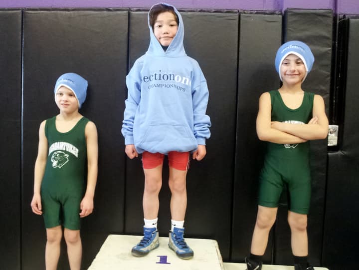 Eight-year-old  August Hibler, center, took first place in the four-county (Dutchess, Putnam, Rockland and Westchester) Section One State Qualifier Wrestling last weekend at John Jay High School in Cross River. 