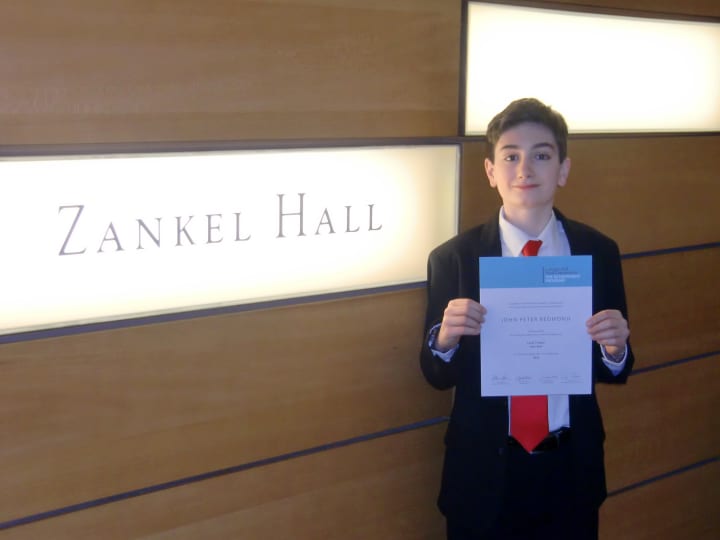 John Peter Redmond shows off his Certificate of Excellence Saturday inside Manhattan&#x27;s Carnegie Hall, where he performed as one of the top young musicians in the tri-state area. 