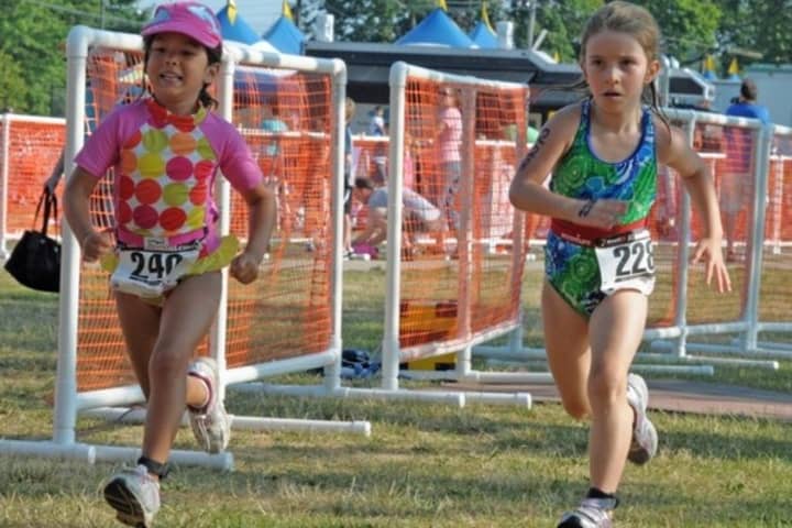 Norwalk&#x27;s Cameron Stewart, right, races with Laura Pippitt of Rhode Island in the Mini Mossman Kids Triathlon last July.