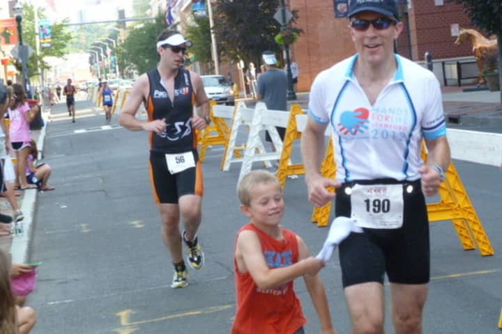 A young boy joins his father for the final stages of the Stamford KIC It Triathlon last summer.