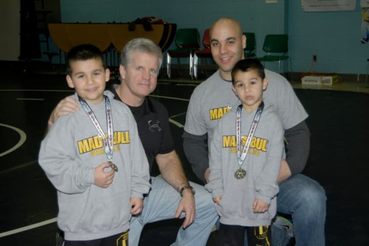 Norwalk Mad Bull wrestlers Jason (left) and Nicky Singer (right) attended last week&#x27;s state tournament with coach Art Schad (second from left) and their dad, Jason.