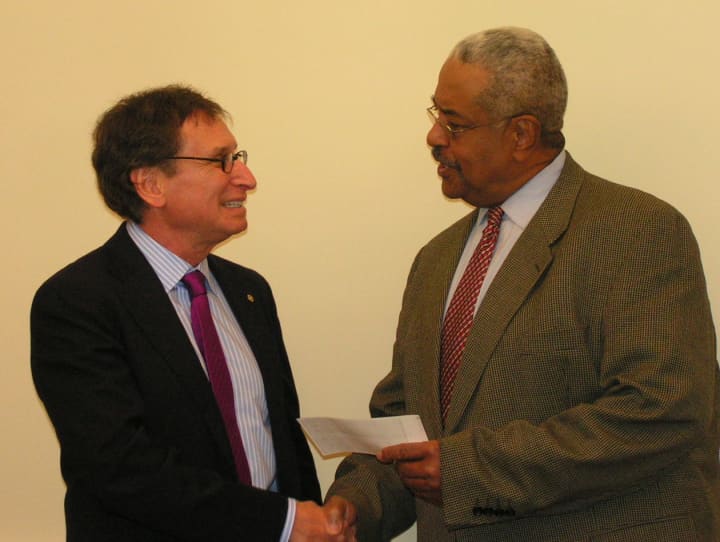 William Callion (right), seen here receiving a check on behalf of the Ferguson Library from Dr. Robert Goldman of the Rotary Club, will be running for mayor. 