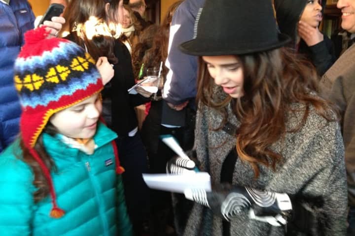 Carly Rose Sonenclar signs an autograph for a young fan at a Mamaroneck party in her honor.