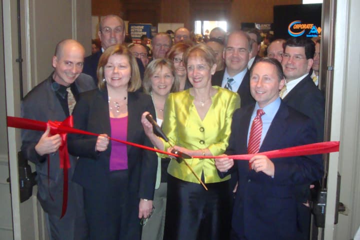 Marsha Gordon, surrounded by fellow members of the Business Council of Westchester, cuts the ribbon at the start of the Mega Mixer Business Expo in Port Chester.