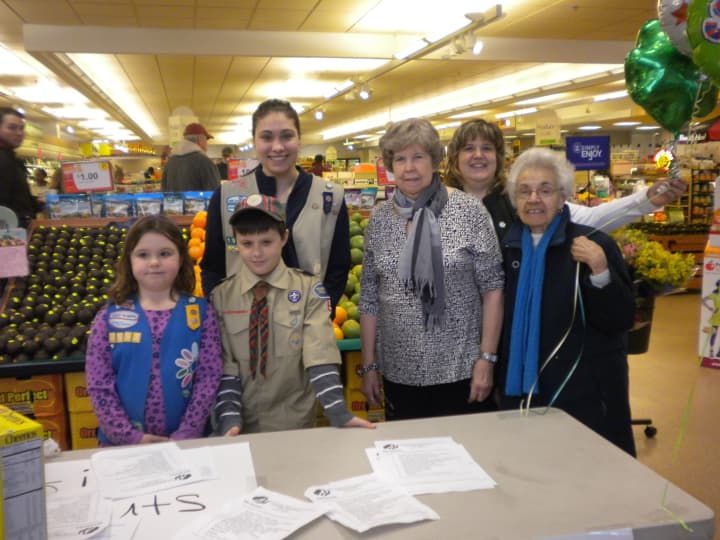Victoria McGuire (back left) gets some help at a food drive at Stop &amp; Shop from her young siblings Isabella (left), 6, and Christopher, 9.