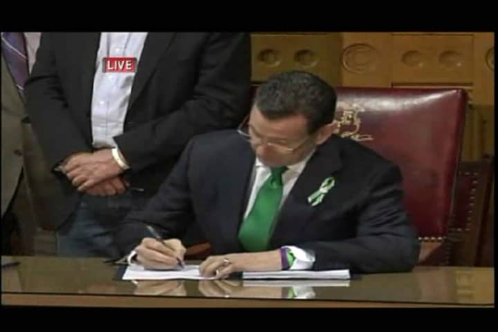 Connecticut Gov. Dannel Malloy signs stricter gun control measures into law in Hartford on Thursday. 