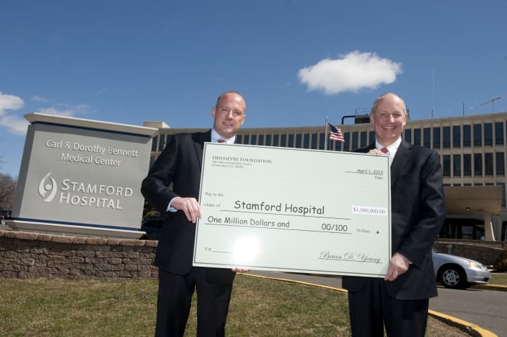 OdysseyRe President and CEO Brian D. Young presents a $1 million check to Stamford Hospital President and CEO Brian G. Grissler.