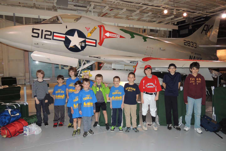 Cub Scout Pack 154 from Goldens Bridge posed in front of a jet on the USS Intrepid.