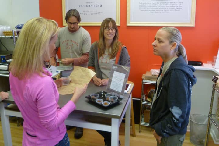 Amy Guerrieri, far right, talks with a customer at GrassRxOOTS, the new vegan station at the Upper Crust Bagel Company in Old Greenwich. Employees Heath Duncan, left, and Jen Eazarsky look on.