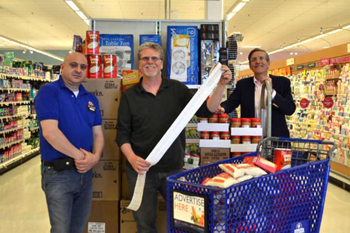 From left, Ferando Paez, grocery manager at the Norwalk Shop Rite, helps Westporters Matt Mandell and Jeff Wieser with the groceries they purchased Wednesday for the Gillespie Center food pantry.