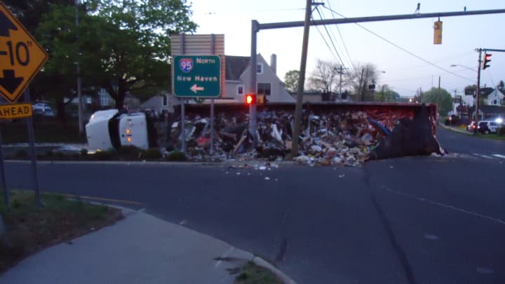A garbage truck is in the road on East Avenue at the I-95 entrance after rolling over early Thursday morning in Norwalk.