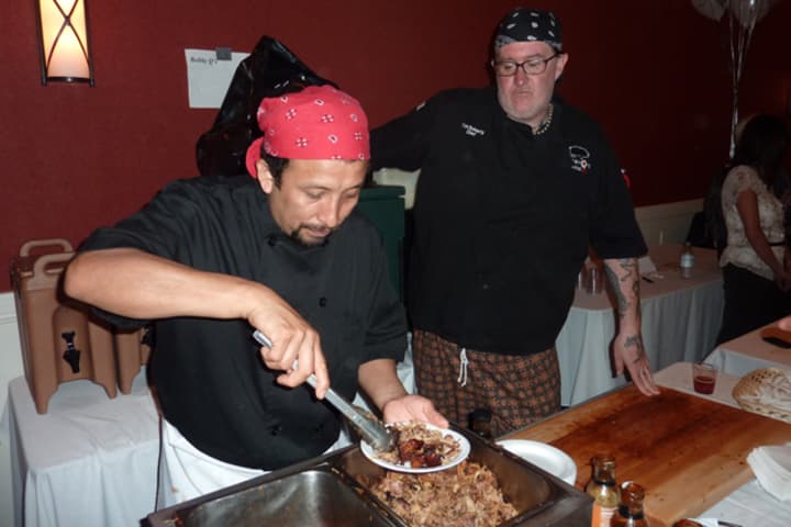 A cook from Bobby Q&#x27;s prepares a plate barbecue for a guest at last year&#x27;s Taste of Westport.