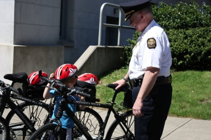 Greenwich Police Chief Jim Heavey shows off the department&#x27;s bicycles to a young resident at last year&#x27;s Police Day event. 