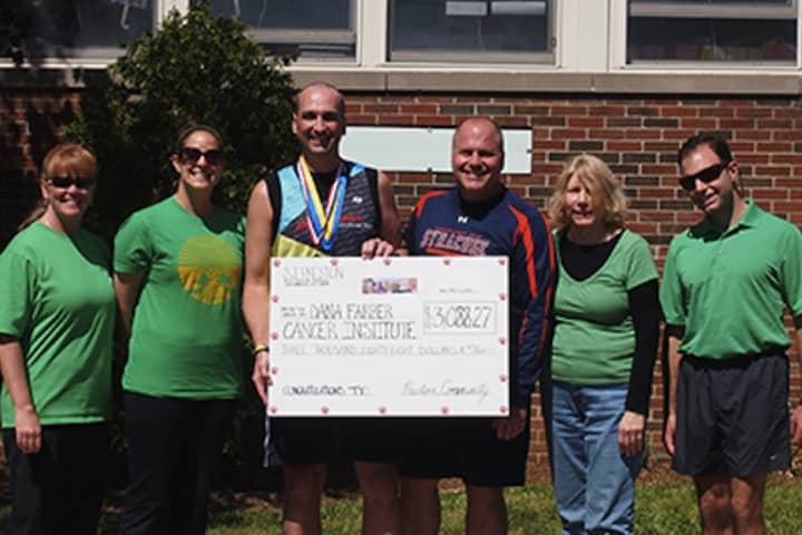 Ty Powers collects a check for the Dana-Farber Cancer Institute after completing the Boston Marathon at S.J. Preston School in Harrison.