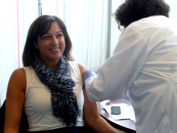 Anne Fountain, director of health and social services for the City of Stamford, seen here getting her annual flu shot, will be one of the panelists discussing the new Avian Influenza A virus, and the prevention of diseases in the office Thursday.