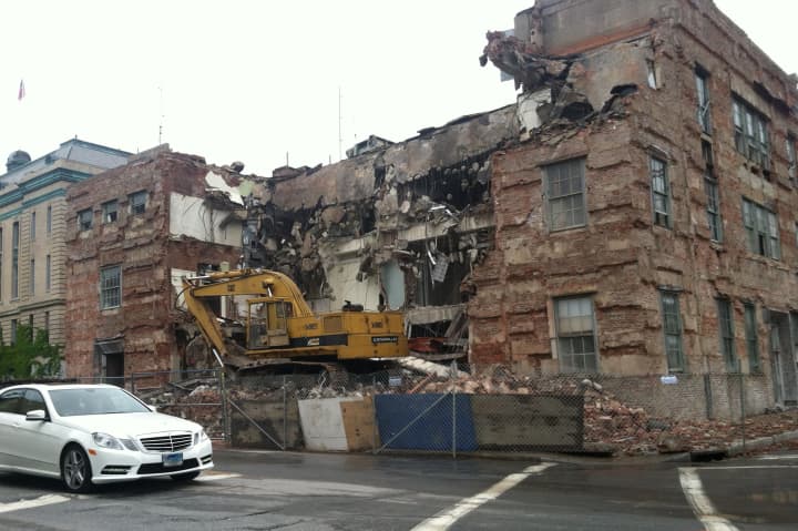 Construction crews demolish the old central fire station on Wednesday to make way for the new $20 million station.