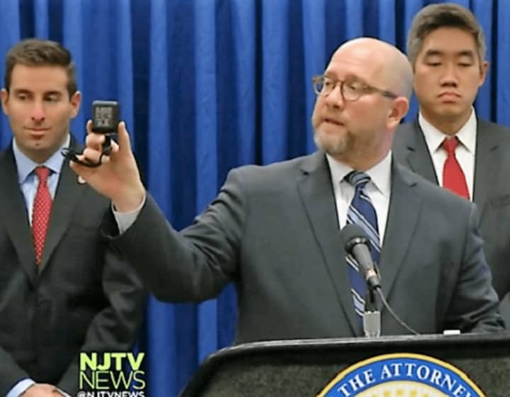 Attorney General Christopher S. Porrino displays a safe care cam during a previous news conference.
