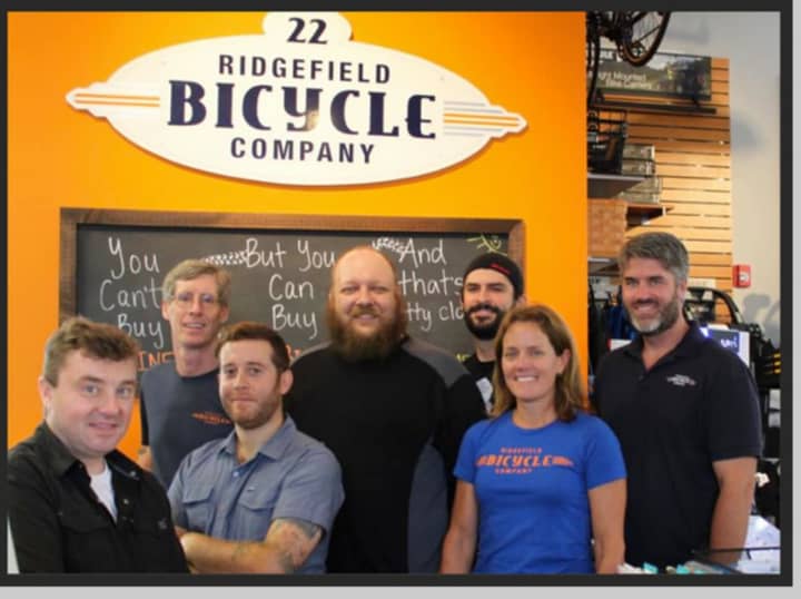 Sean Dowd, right, and his wife, Jacqui, stand with the Ridgefield Bicycle Company team. The business was named last week as one of America&#x27;s Best Bike Shops for the second straight year. 
