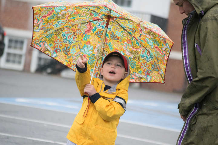 A child keeps dry under an umbrella during Sunday&#x27;s Run Like A Mother 5k race in Ridgefield.