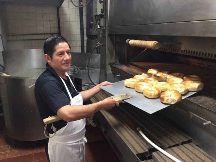 Salvatore Sarmiento pulls a batch of bagels out of the oven at Bagel Train in Suffern.