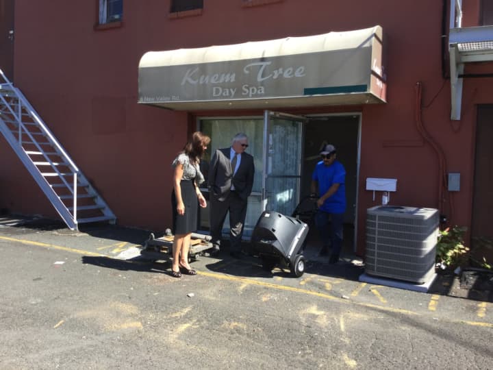 Rockland County Attorney Thomas Humback and Assistant Attorney Larraine Feiden watch as workers hired by the county remove property from a massage parlor in New City.