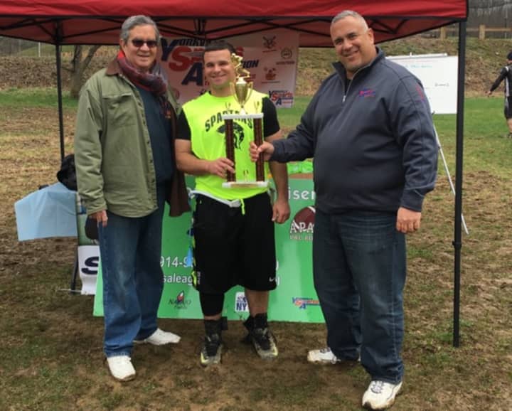 Larry Eidelman, right, of Yorkville Sports Association and Bruce Apar,  left, of Harrison Apar Field of Dreams Foundation congratulate the captain of the winning Spartans in the April 3 Apar Pro Bowl at Navajo Fields.