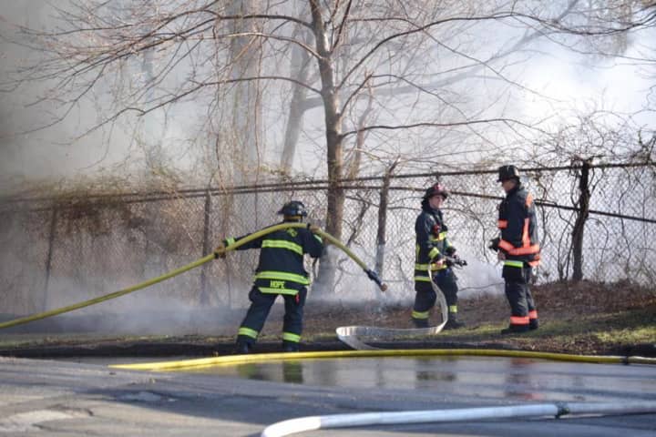 Firefighters battled a fire at Frog Pond Lane and East Main Street in Stratford Sunday at the former Raybestos site. It was first reported as a brush fire, but two buildings were destroyed by the blaze.