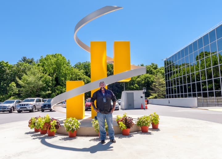 William Seepaul Jr. stands in front of a sculpture he created at Synchrony Financial in Stamford.