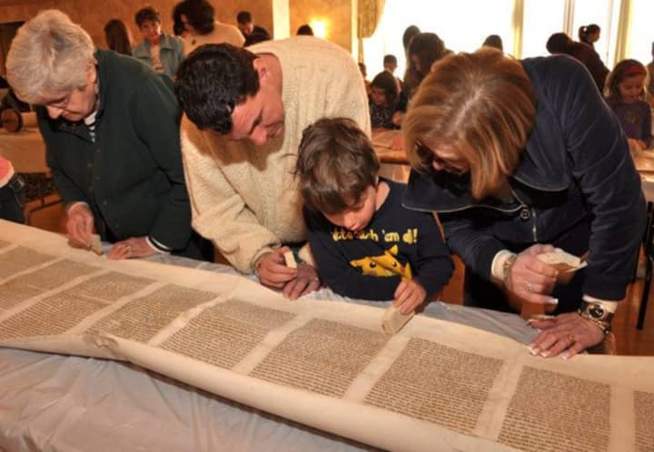 Members of the Reform Temple of Rockland look at Torah scrolls. Temple Beth El in Spring Valley, which recently combined its congregation with that of Temple Beth Torah in Nyack, will be moving its Torahs to the new location this Sunday.