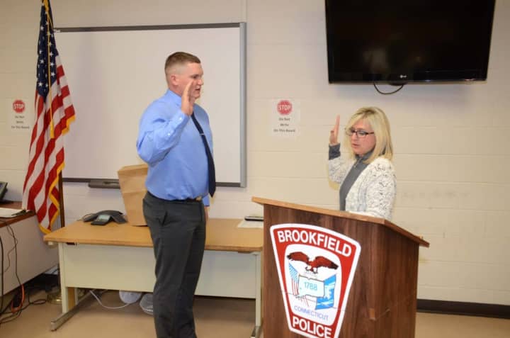 Tommy Robbins, a graduate of Danbury High School, takes the oath of office at the Brookfield Police Department. He begins training this week.
