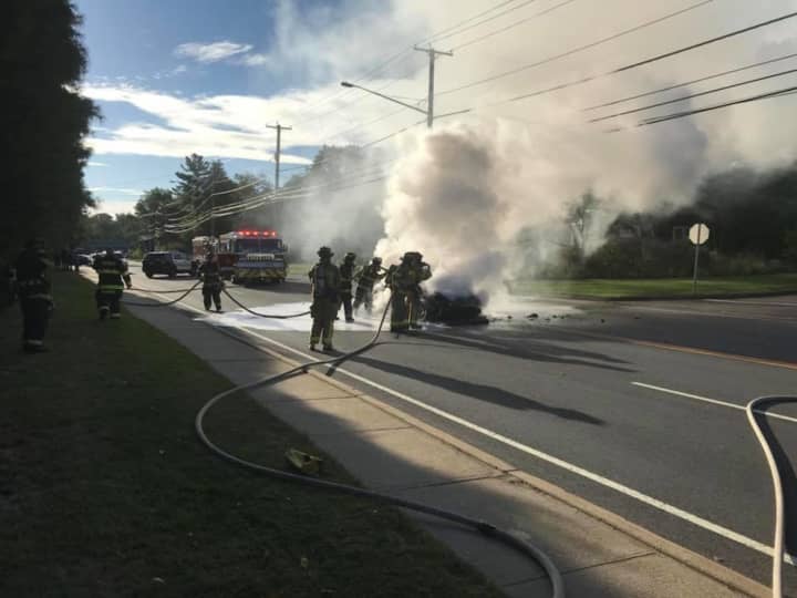 Firefighters extinguish a car fire on White Plains Road in Trumbull on Friday morning.