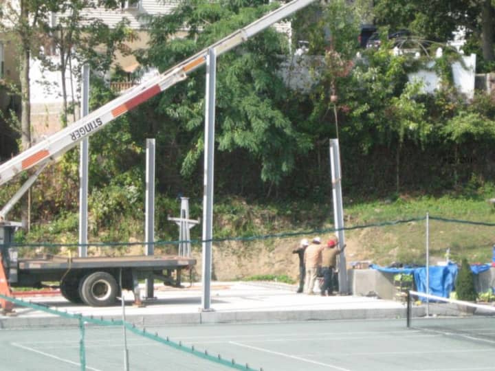 Construction crews in Mount Vernon installing steel beams around the tennis courts at Memorial Field. 