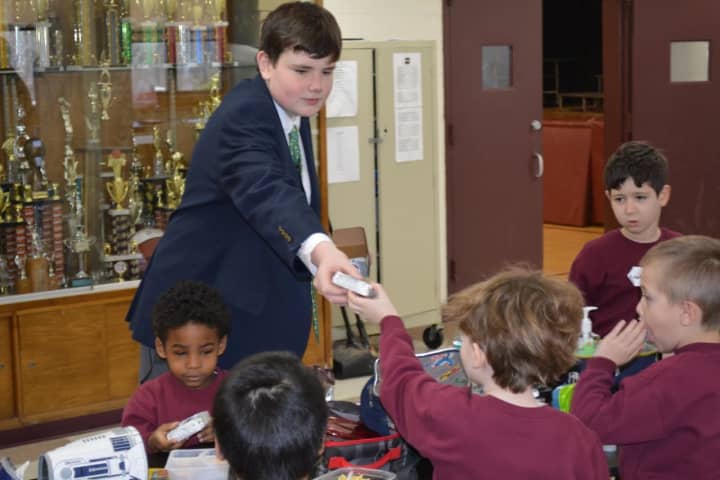 8th Grader Connor Breen of Scarsdale handed out ice cream treats as part of his duties while taking part in “Principal for a Day” at Iona Prep.