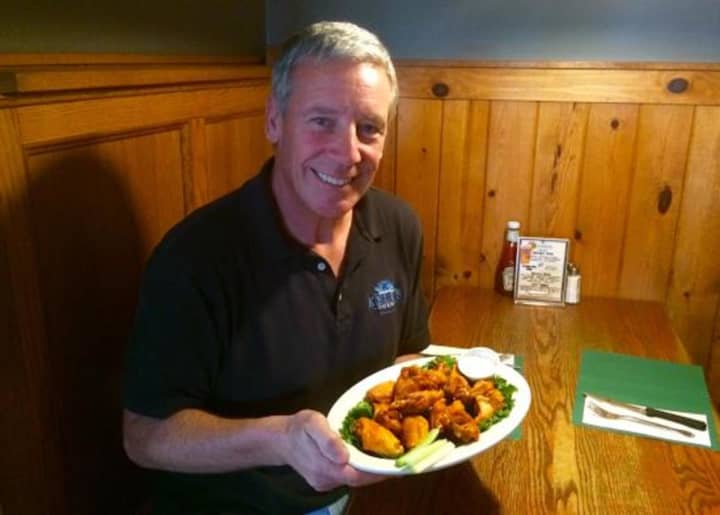 Kelly Quinn, the owner of Kelly&#x27;s Corner in Brewster, with a plate of wings.