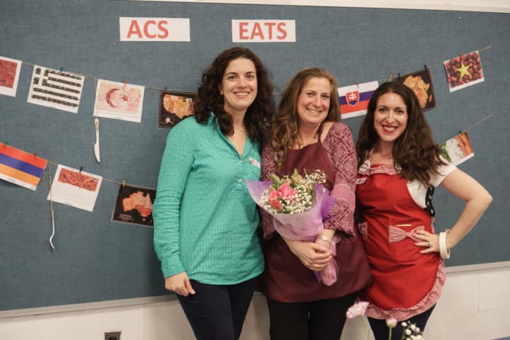 Wendy Leynse (center) receives flowers to mark her last year as an ACS Eats! event organizer. Pictured with her are event organizers Erin Scordo (l) and Jamie Sclafane (r).