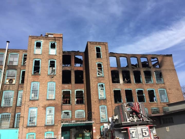 Yonkers firefighters remained at the scene of the former Alexander Smith Carpet building into the afternoon following Monday morning&#x27;s fire.