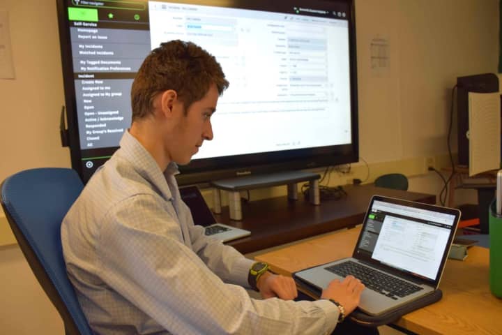 Liam Siegal, a Bronxville High School senior and Student Help Desk member, answers a ticket before resolving a technology issue in the district.