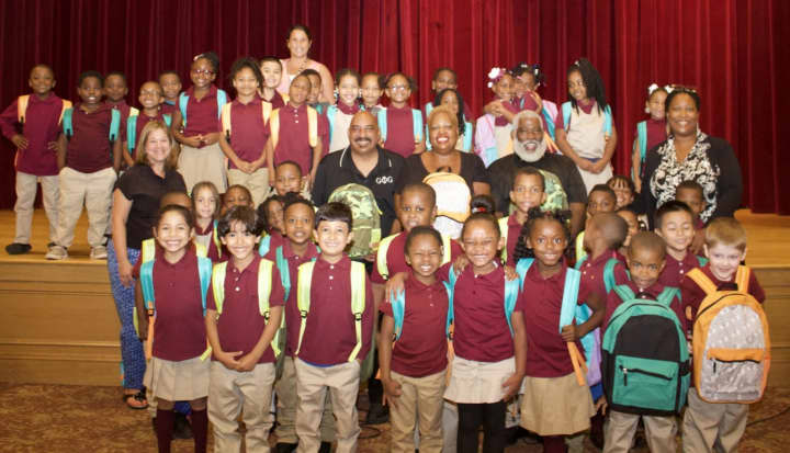 Happy Graham Elementary School first-graders show off their new backpacks and school supplies after receiving them from representatives of the Graham Elementary School Alumni Association.
