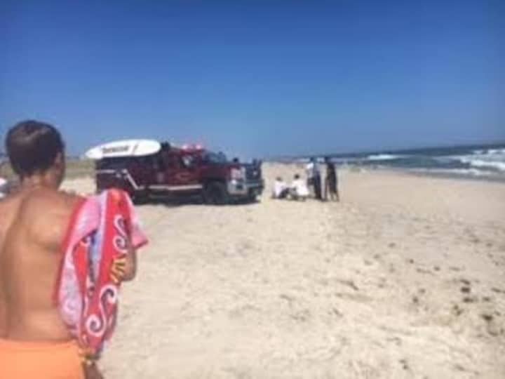 Hank Joselson watches as EMS and police work on the man he saved from drowning at the beach.