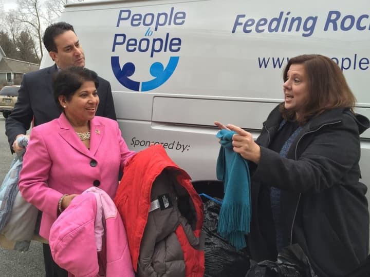 Legislators Alden H. Wolfe and Aney Paul present the coats and sweaters donated in the first Winter Coat drive last year to Diane Serratore, executive director of People to People.