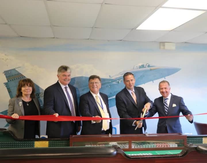 Local officials celebrate the ribbon cutting at the new dealer school at Stewart Airport.