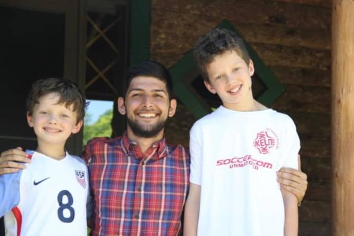 Jackson (left) and Gray (right) Scarlett with their au pair, Ali Hoseinzadeh, who is nominated for an international award.