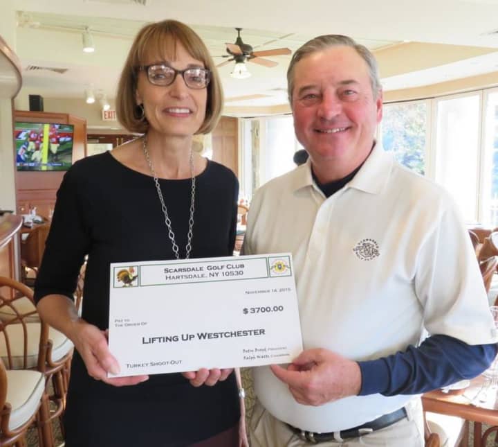 Chris Schwartz, left, director of development for Lifting Up Westchester, receives check from Ralph Watts, tournament chair for the Turkey Shoot Out at Scarsdale Golf Club.