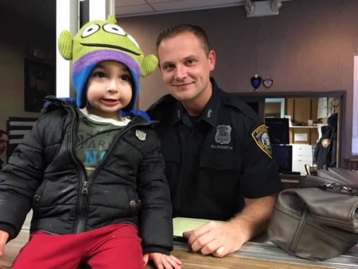 Landon Pruyne, 3, poses with a Yorktown police officer after turning in a wallet he found.
