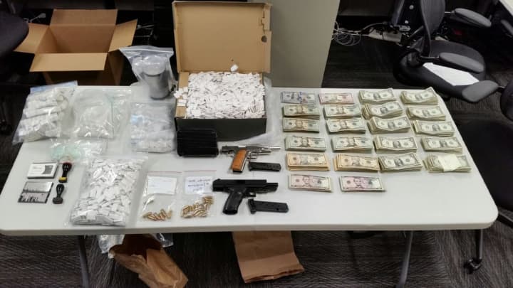 Officials seized two loaded handguns, 2.5 kilos (more than five pounds) of heroin with a street value of more than $1.5 million and $100,000 in cash.