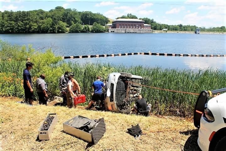 Mulitple first responders work to save occupants in a car that crashed into the reservoir.